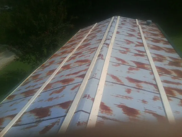 Rusted metal roof panels with new wood purlins before replacement — Storm Damage Roof Repair in Corrigan by Roofing Brothers