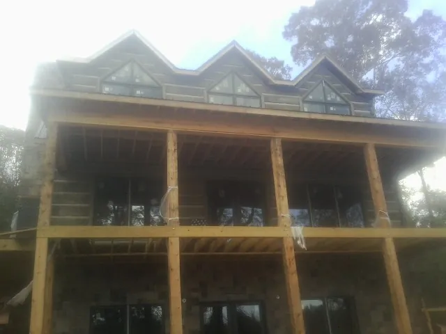 Dormers and porch framing on a large log home under construction — Roof Coating work by our crew in Corrigan